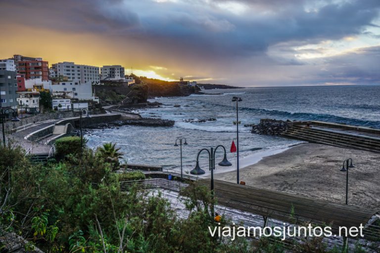 Piscinas y playas en bajamar, con un atardecer de fondo.