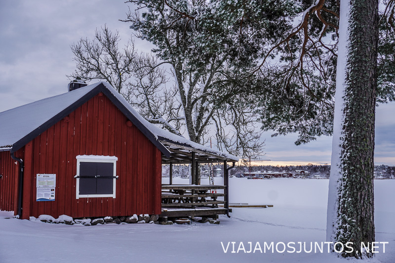 Casa roja junto a lago congelado durante el invierno en Suecia