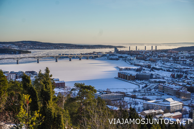 Vista de lago parcialmente helado junto a una ciudad en Suecia