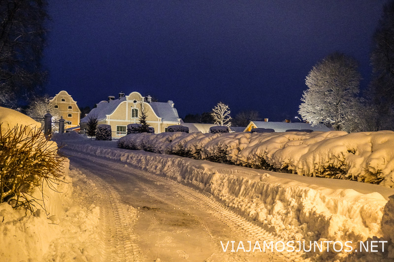 Casas cubiertas de nieve iluminadas durante una noche de invierno en Suecia