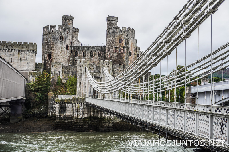 Fortaleza del Castillo de Conwy junto al puente colgante histórico sobre el río en Gales